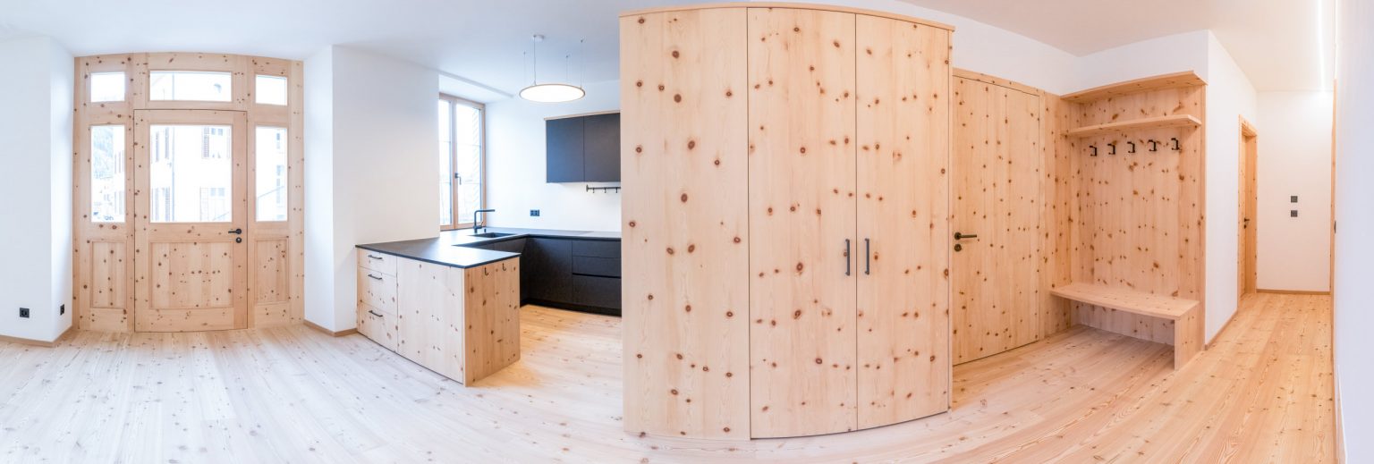 1. Hochwertige, natürliche Holzverkleidung und moderne Küchenausstattung in einem lichtdurchfluteten Raum mit minimalistischer, nachhaltiger Optik.