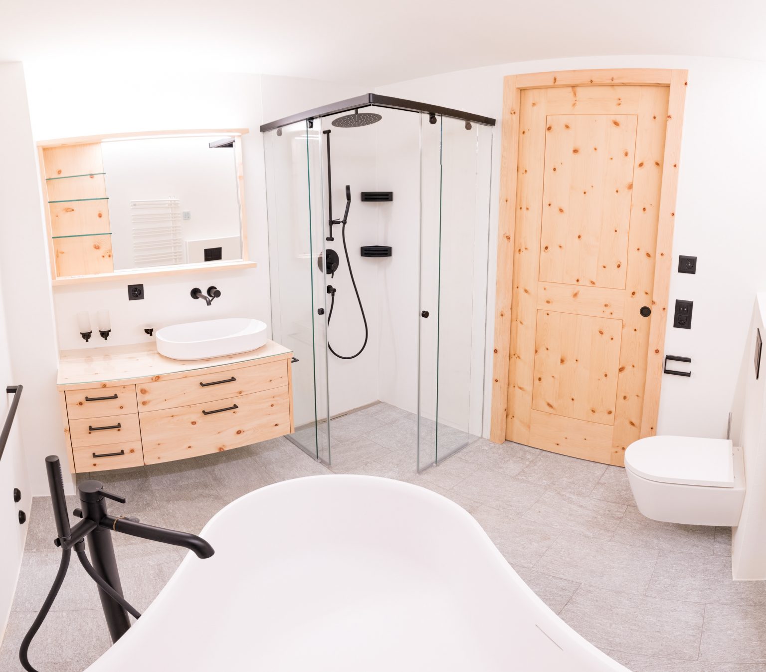 Entspannendes modernes Badezimmer mit Holzakzenten, begehbarer Duschkabine, freistehender Badewanne und eleganten schwarzen Armaturen – stilvolle Wellness-Oase für optimale Erholung.