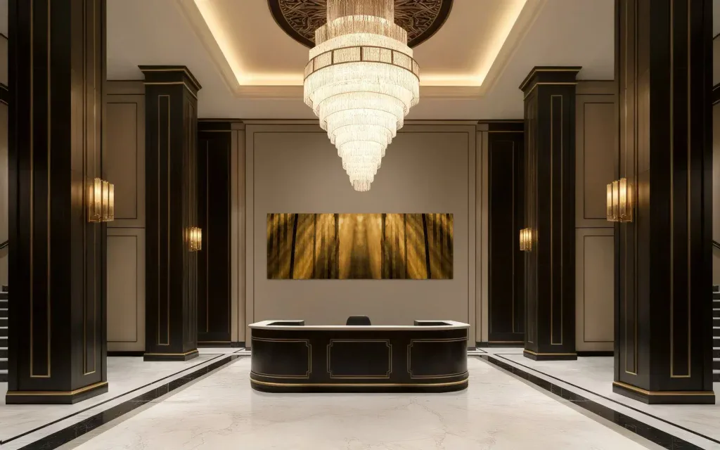 Elegantes Hotelrezeption mit dunklem Holz, goldenen Akzenten und beeindruckendem Kronleuchter für einen luxuriösen Eindruck.