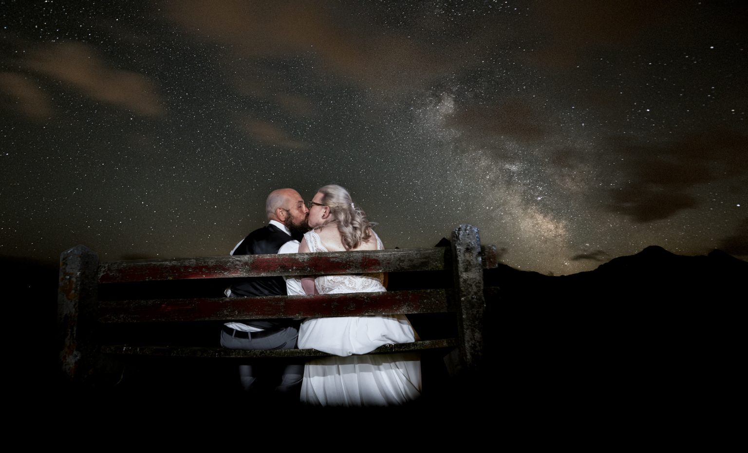 1. Paare im Hochzeits- oder Paarshooting unter Sternen mit Blick auf die Milchstraße, romantisch und zauberhaft, in der Natur fotografiert.