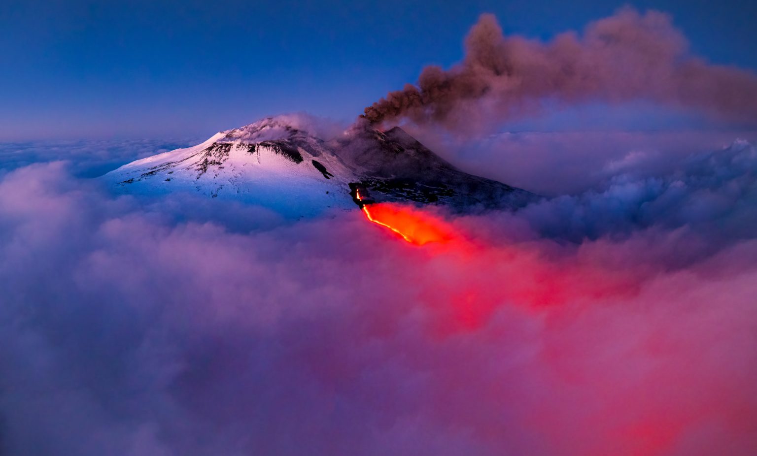 Rauchender Vulkan mit Lavastrom, spektakuläre Naturaufnahme, eruptiver Vulkan, beeindruckende Vulkanaktivität, beeindruckende Vulkanfotografie, Naturerlebnis, Naturwunder, Erdspektakel.